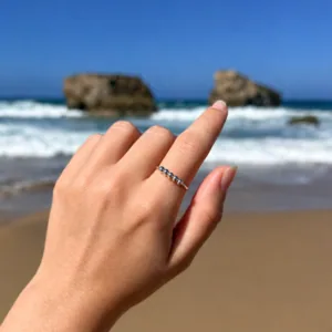 Main avec la bague anti-stress Valentina argentée sur la plage